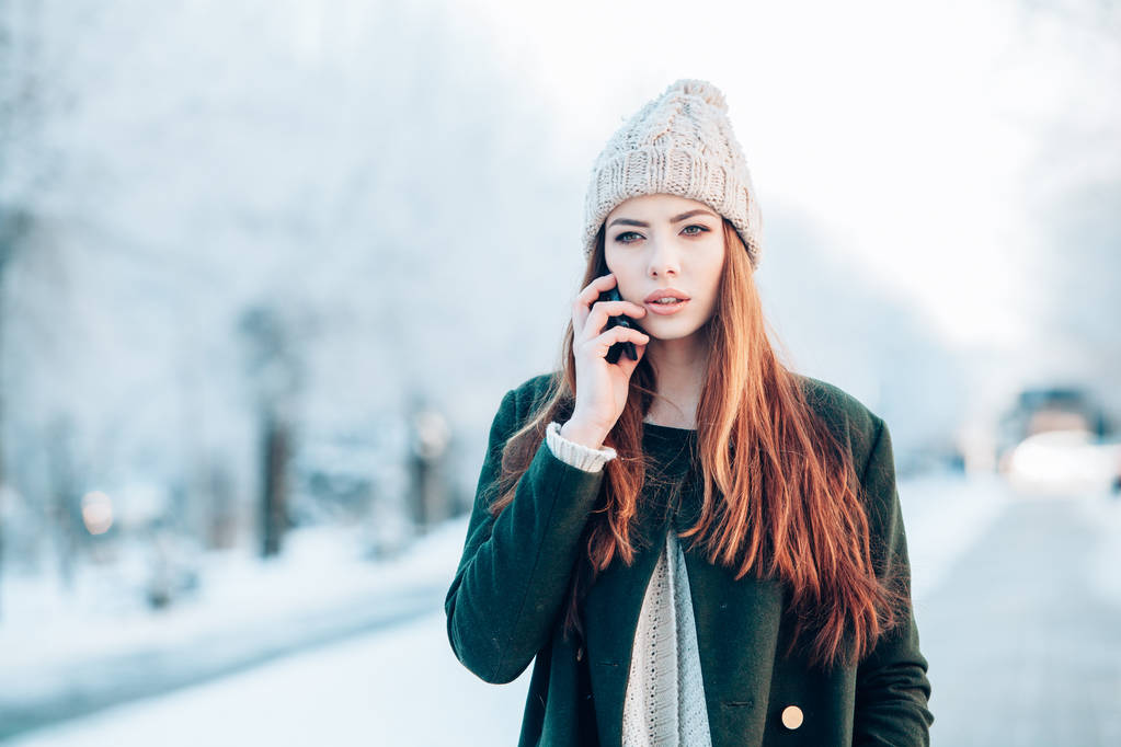 Jovem mulher sorrindo com telefone inteligente e paisagem de inverno
 . - Foto, Imagem