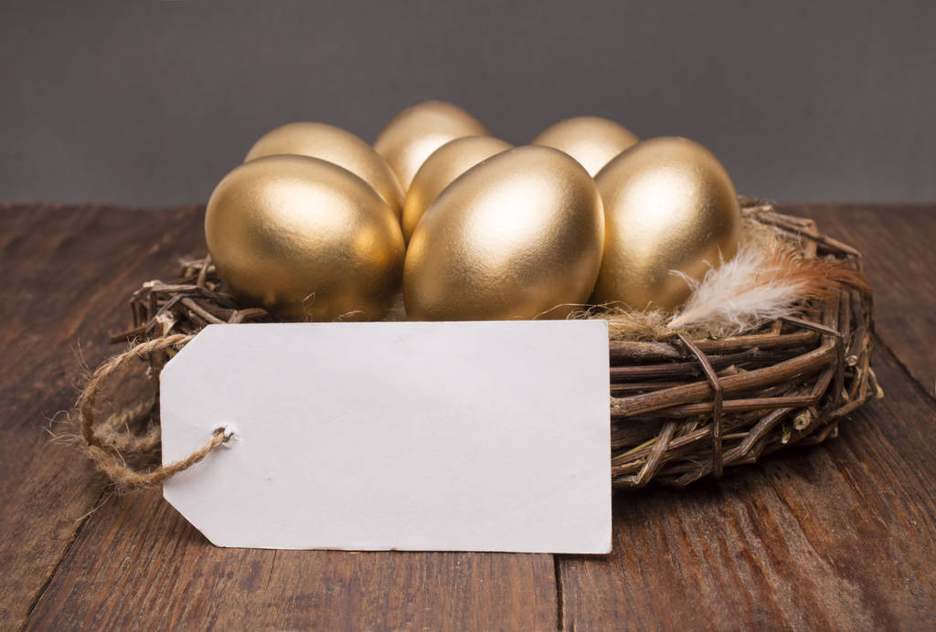 Hnízdo s zlatá vejce s značku a místo pro text na dřevěné pozadí. Koncept úspěšný odchod do důchodu - Fotografie, Obrázek