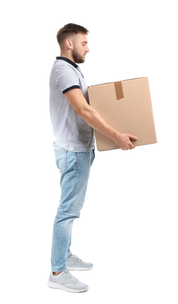 白い背景の上のダン ボール箱を運ぶ若い男の完全な長さの肖像画。姿勢の概念 - 写真・画像