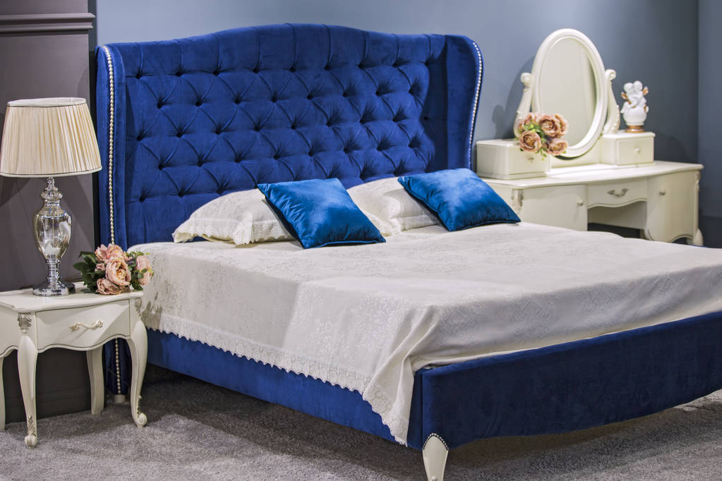 Lüks royal yatak odasında mavi kadife yatak ve beyaz komidin ile antika stili. - Fotoğraf, Görsel