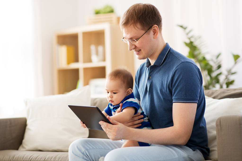 pai feliz e bebê filho com tablet pc em casa
 - Foto, Imagem