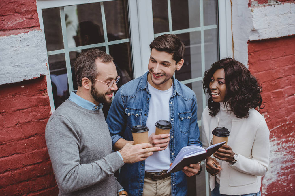 multiethnische Kollegen lächeln, reden über die Arbeit und trinken Kaffee - Foto, Bild