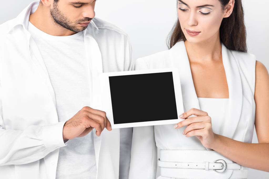 Nahaufnahme eines erwachsenen Paares in völligem Weiß mit leerem Bildschirm auf digitalem Tablet-Bildschirm isoliert auf weißem Hintergrund - Foto, Bild