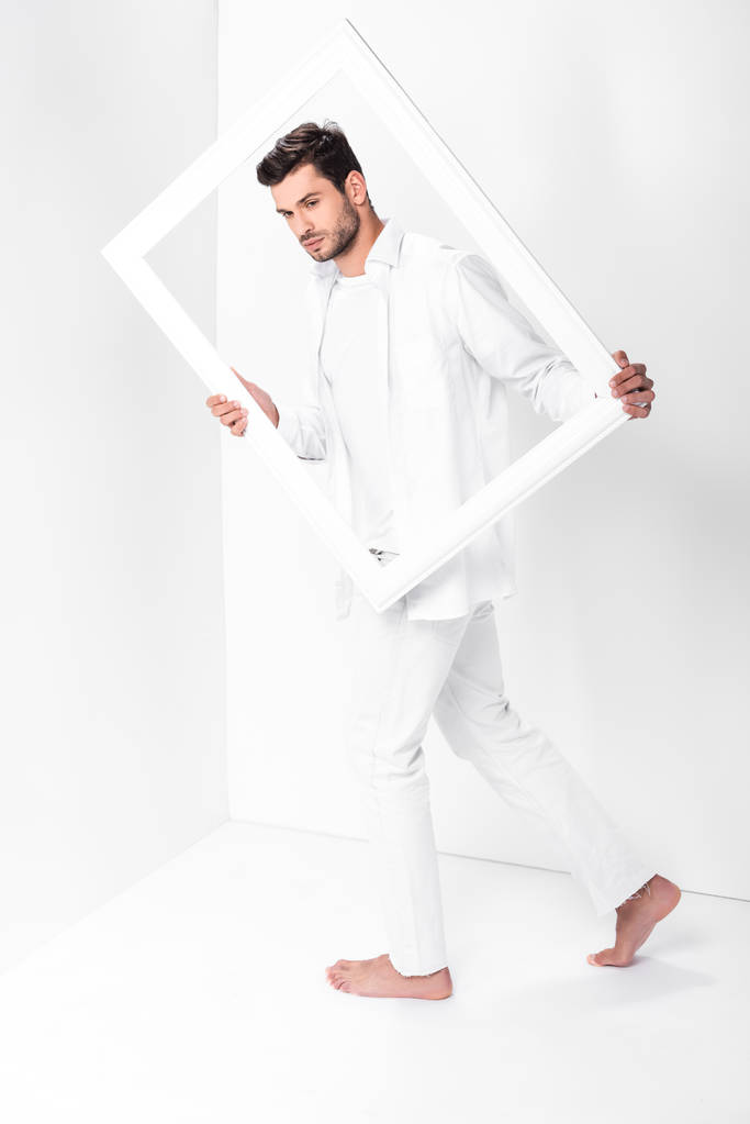 bonito descalço adulto homem no total branco com quadro
  - Foto, Imagem