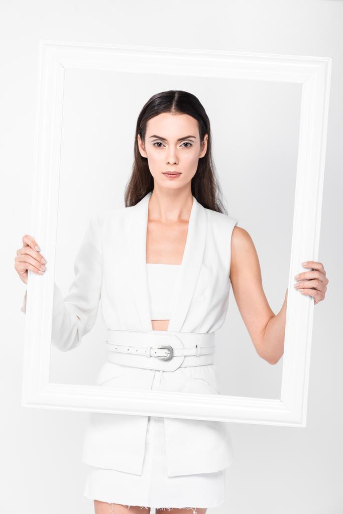 aantrekkelijke vrouw poseren met frame geïsoleerd op wit - Foto, afbeelding