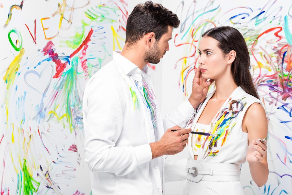 adult gentle couple with drawing equipment against painted wall - Photo, Image