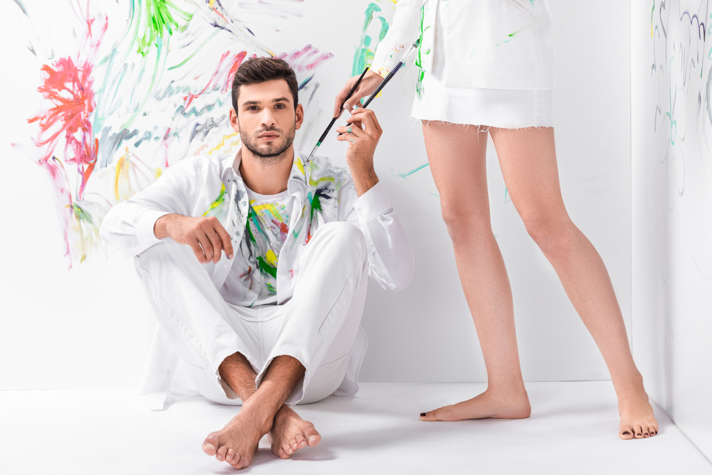 primer plano de pareja en ropa blanca pintada con equipo de dibujo
 - Foto, Imagen