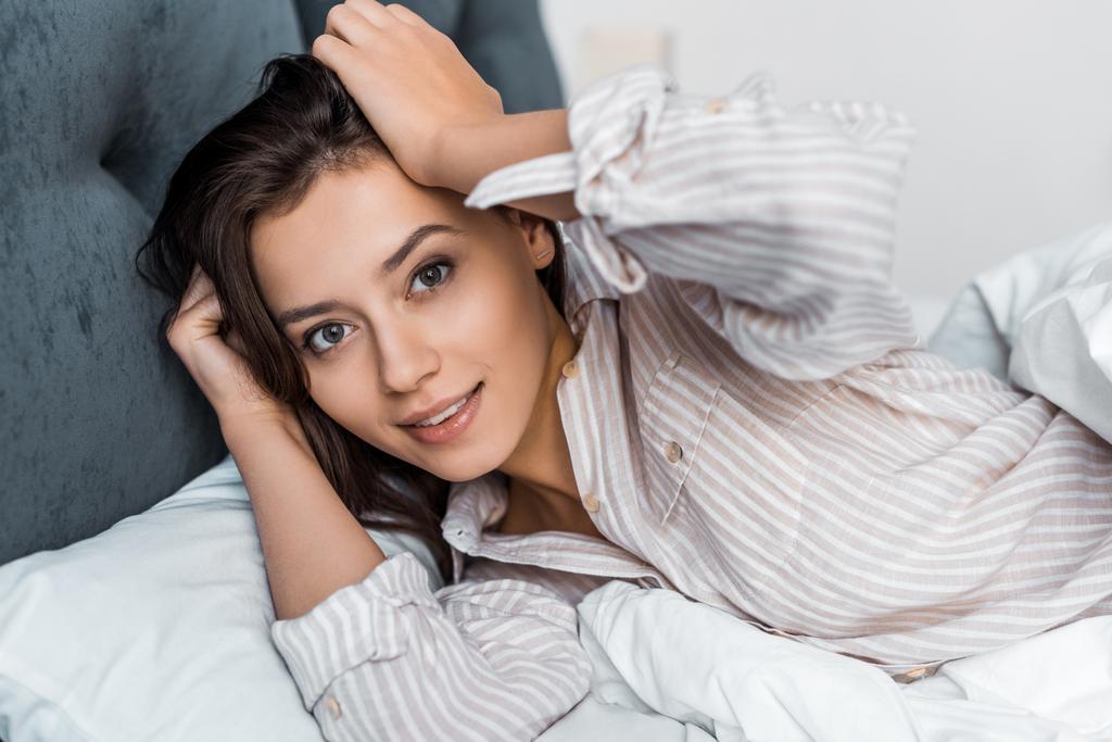 hermosa morena chica en pijama relajarse en la cama
 - Foto, Imagen