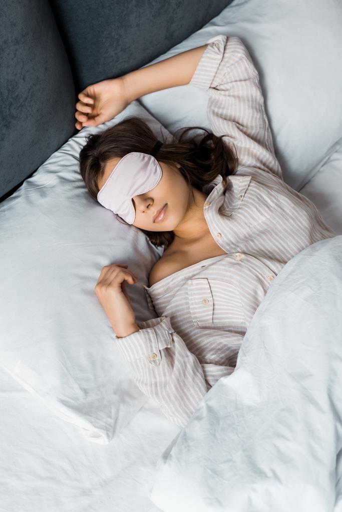 привлекательная молодая женщина спит в маске глаза в постели
 - Фото, изображение