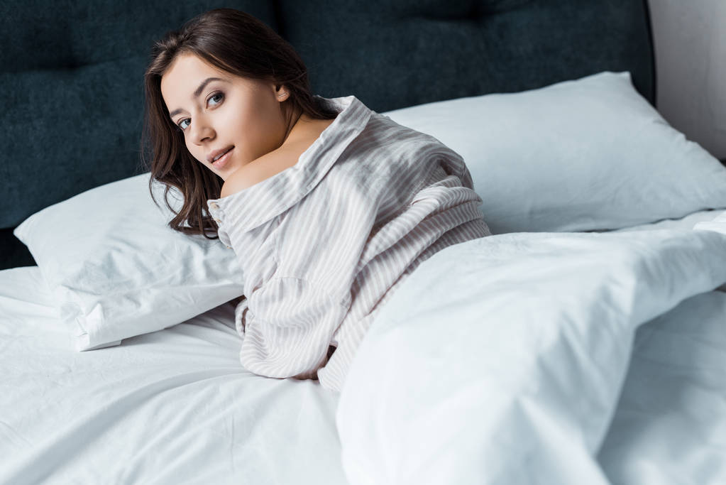 ελκυστική νεαρή γυναίκα στο πιτζάμες ξεκούραστη στο κρεβάτι - Φωτογραφία, εικόνα