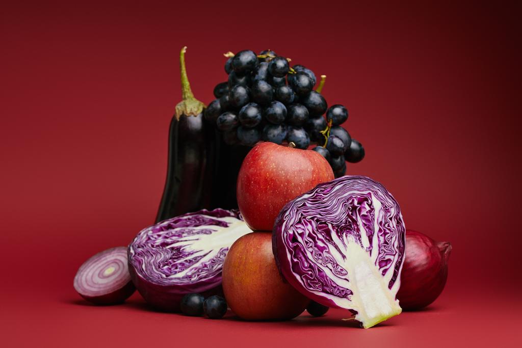 крупный план яблок, винограда, баклажанов, капусты и лука на красный цвет
  - Фото, изображение