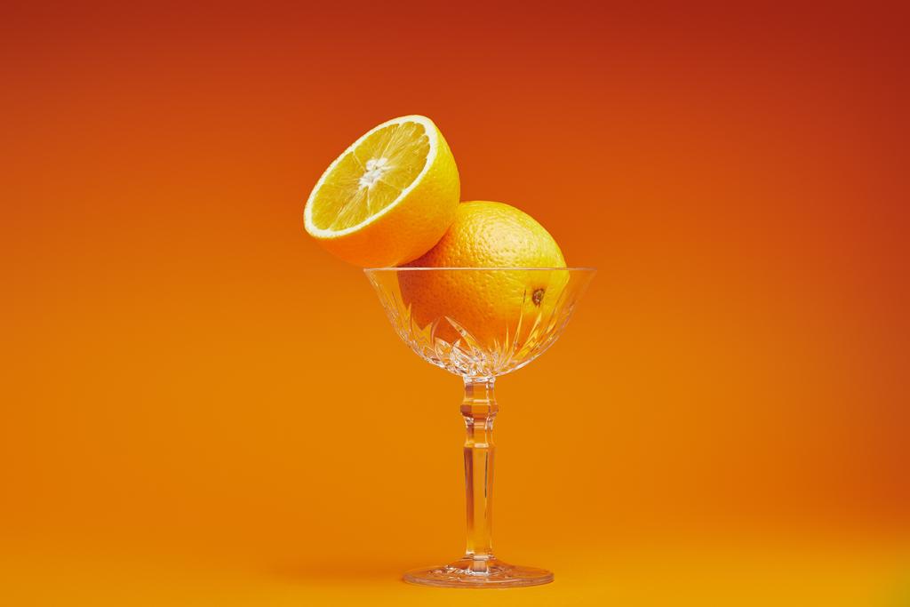 крупным планом вид свежих спелых апельсинов из стекла на оранжевом фоне
 - Фото, изображение