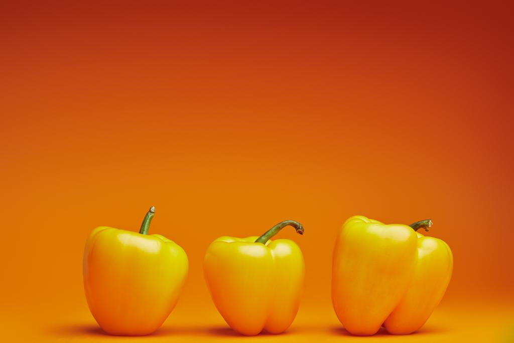 Προβολή με μεγέθυνση από νωπά ώριμα Πιπέρια κουδουνιών σε πορτοκαλί φόντο   - Φωτογραφία, εικόνα