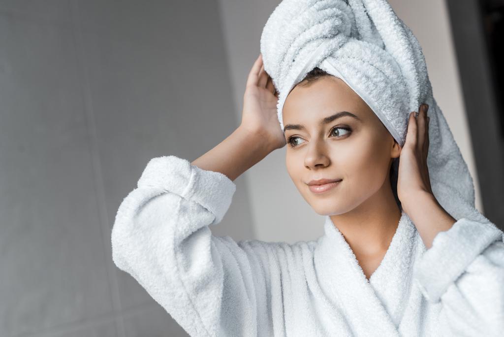 smiling young woman in white bathrobe wearing towel on head - Photo, Image