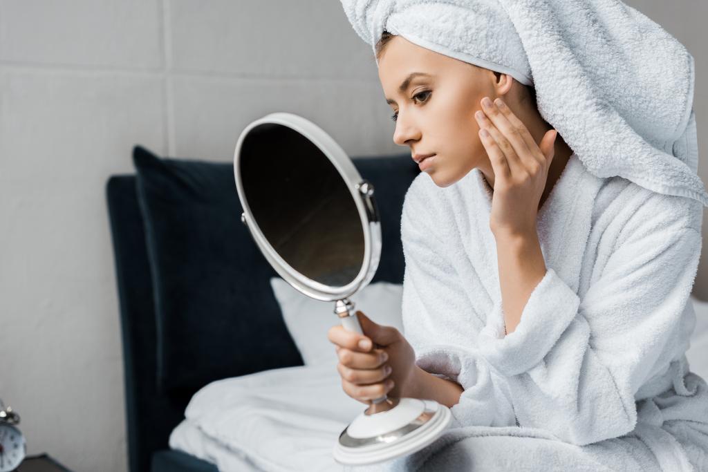 attraktive junge Frau, die ihre perfekt saubere Haut im Spiegel betrachtet    - Foto, Bild