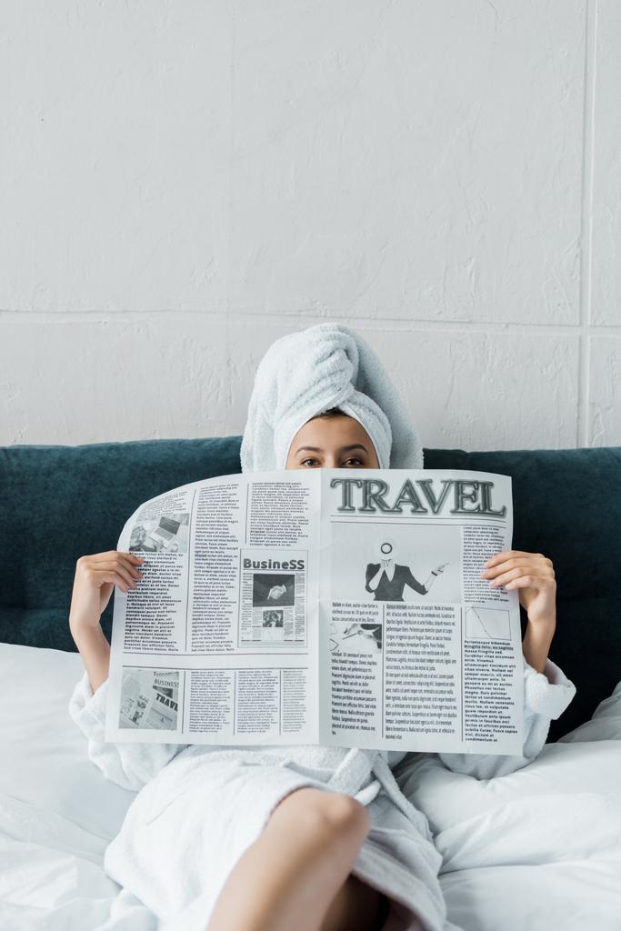 mujer joven escondida detrás de un periódico de viaje por la mañana
   - Foto, imagen