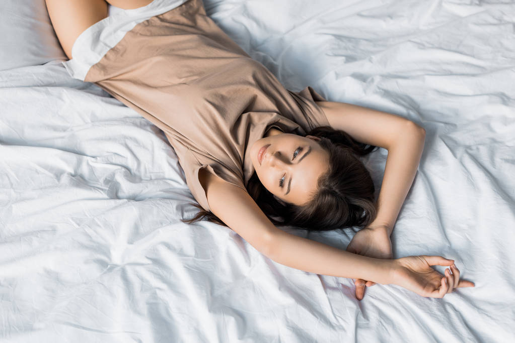 όμορφη νεαρή γυναίκα με ανάπαυση στο κρεβάτι το πρωί τις πυτζάμες - Φωτογραφία, εικόνα