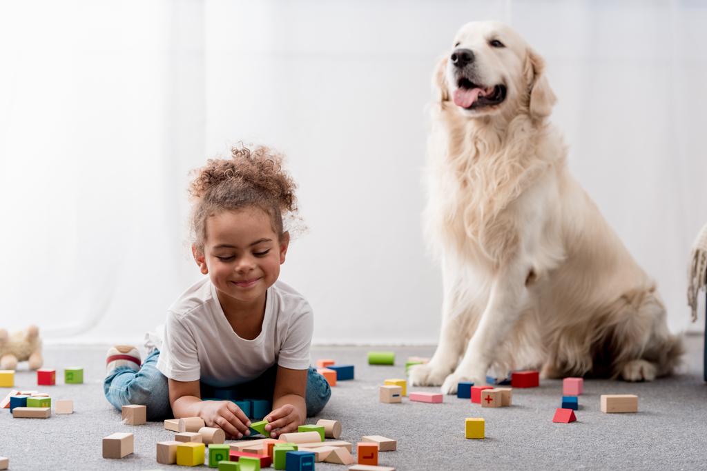 Oyuncak küpleri ve köpek ile oynayan sevimli Afro-Amerikan çocuk  - Fotoğraf, Görsel