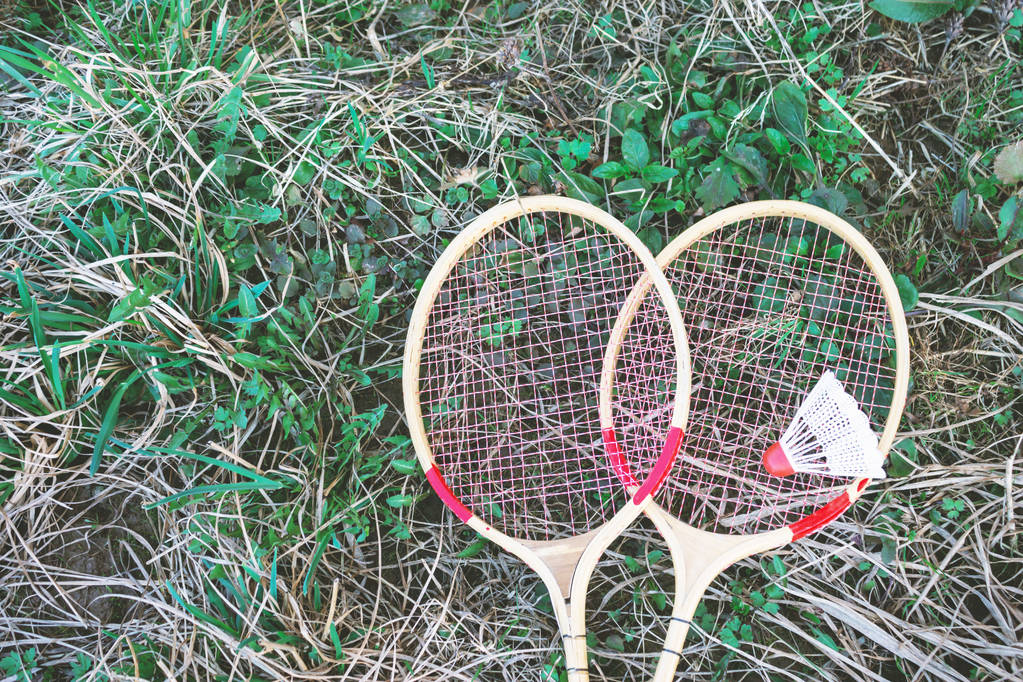 Navette blanche et raquette de badminton couchée sur l'herbe verte
. - Photo, image