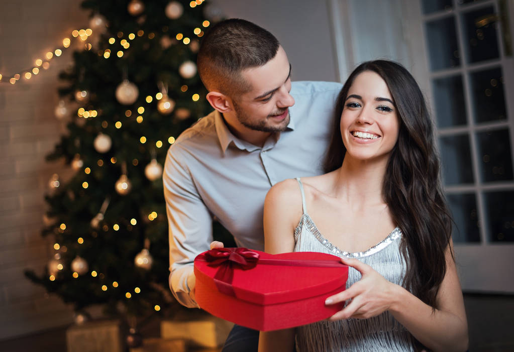 Man geeft een kerstcadeau aan zijn vriendin - Foto, afbeelding