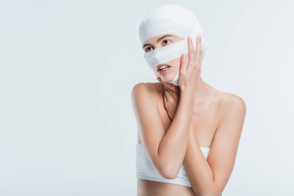 femme avec des bandages touchant la tête isolé sur blanc
 - Photo, image