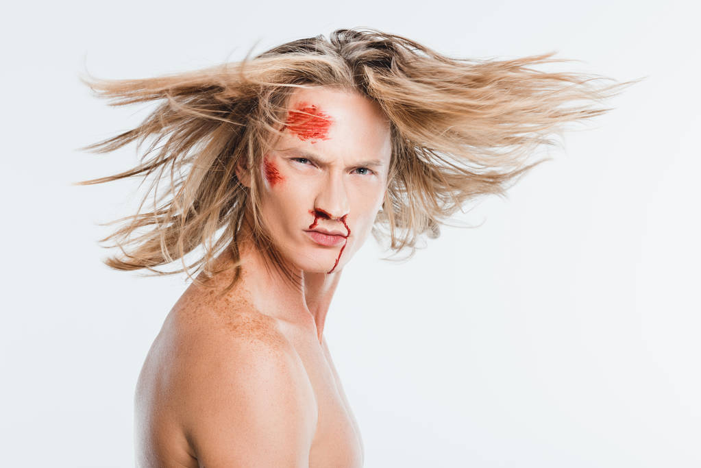volwassen man met bloedige kneuzingen op gezicht wuivende haren geïsoleerd op wit - Foto, afbeelding