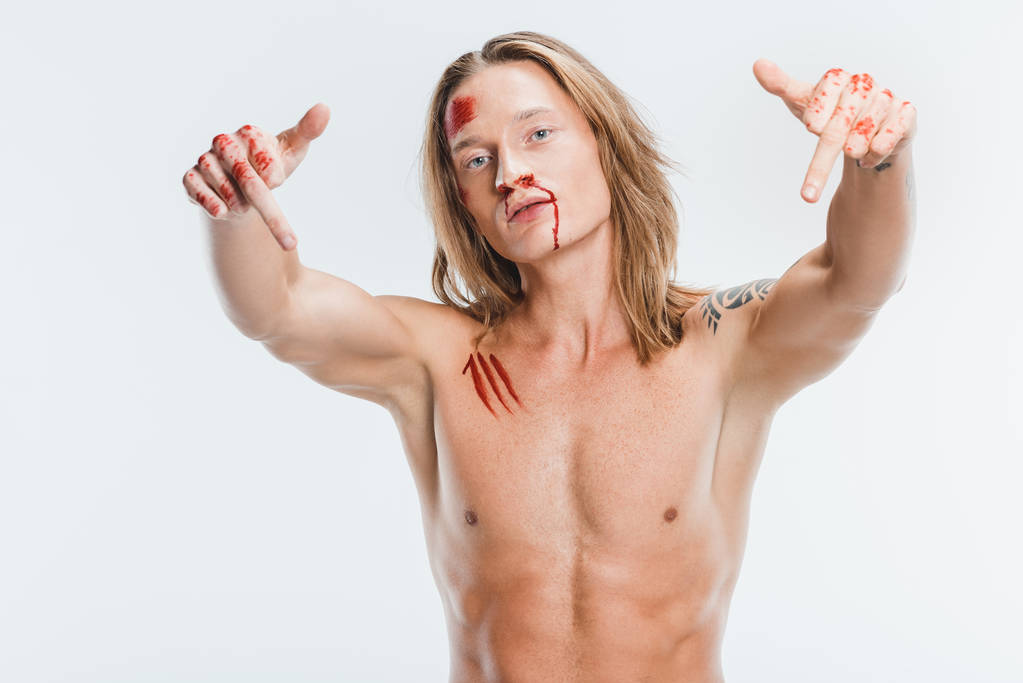 γυμνό όμορφος άνδρας με αιματηρή πληγές δείχνει μεσαία δάχτυλα που απομονώνονται σε λευκό - Φωτογραφία, εικόνα
