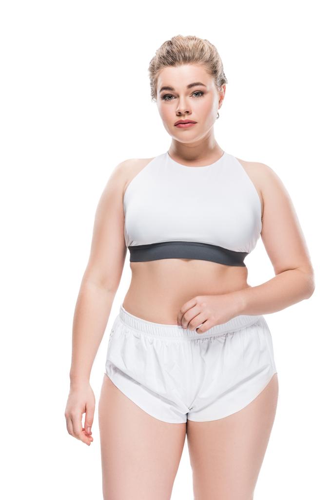 atractiva chica con sobrepeso en ropa deportiva mirando a la cámara aislada en blanco
 - Foto, imagen
