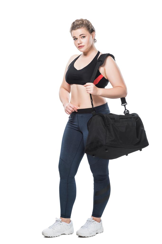 vista de longitud completa de atractivo tamaño joven más mujer con bolsa de deporte mirando a la cámara aislada en blanco
  - Foto, imagen