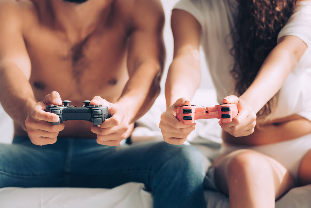 abgeschnittenes Bild eines Paares, das zu Hause am Steuerknüppel Videospiel spielt - Foto, Bild