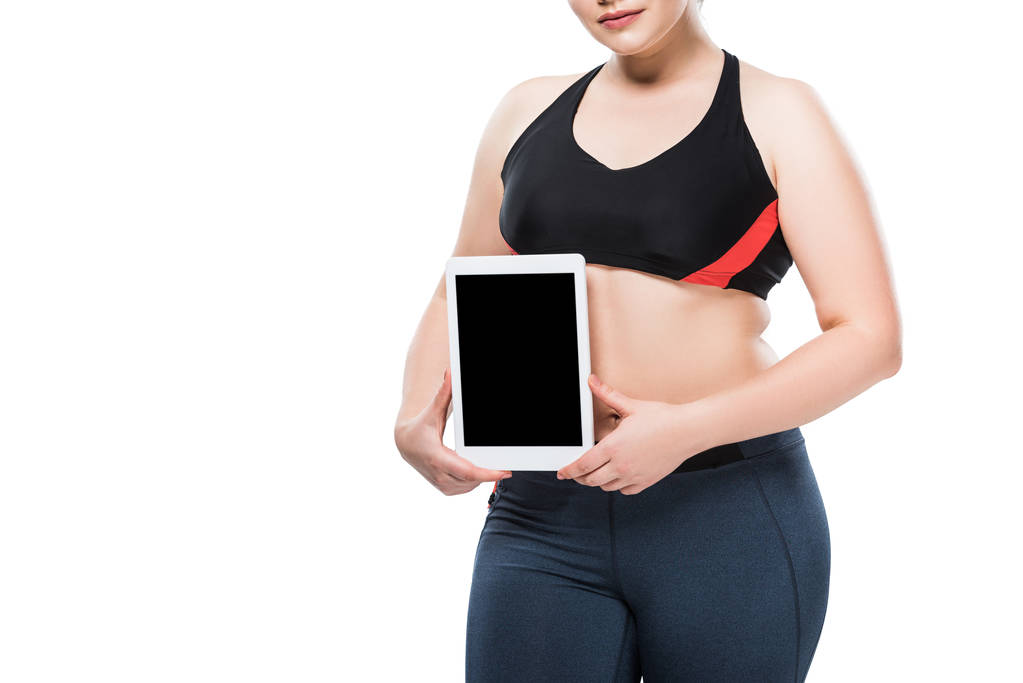 rajattu kuva nuori ylipainoinen nainen urheiluvaatteet tilalla digitaalinen tabletti eristetty valkoinen
  - Valokuva, kuva