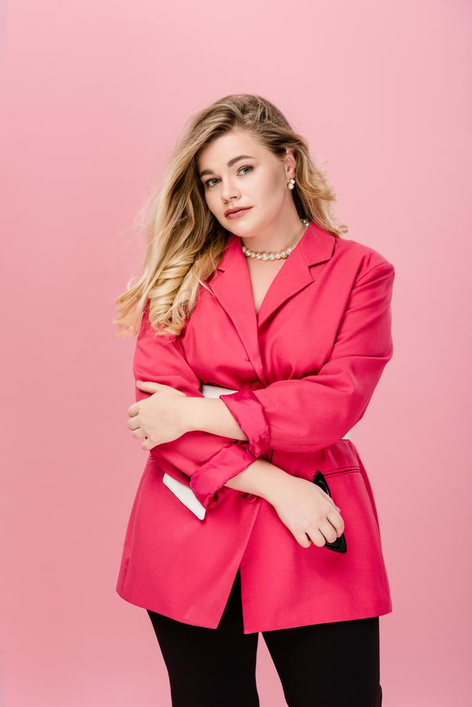 atractivo joven más mujer de tamaño en elegante chaqueta rosa mirando a la cámara aislada en rosa
 - Foto, Imagen