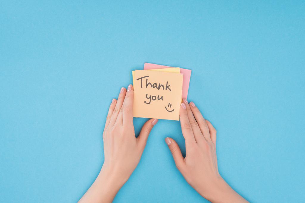 cropped person holding colorful sticky notes with thank you lettering isolated on blue background - Photo, Image