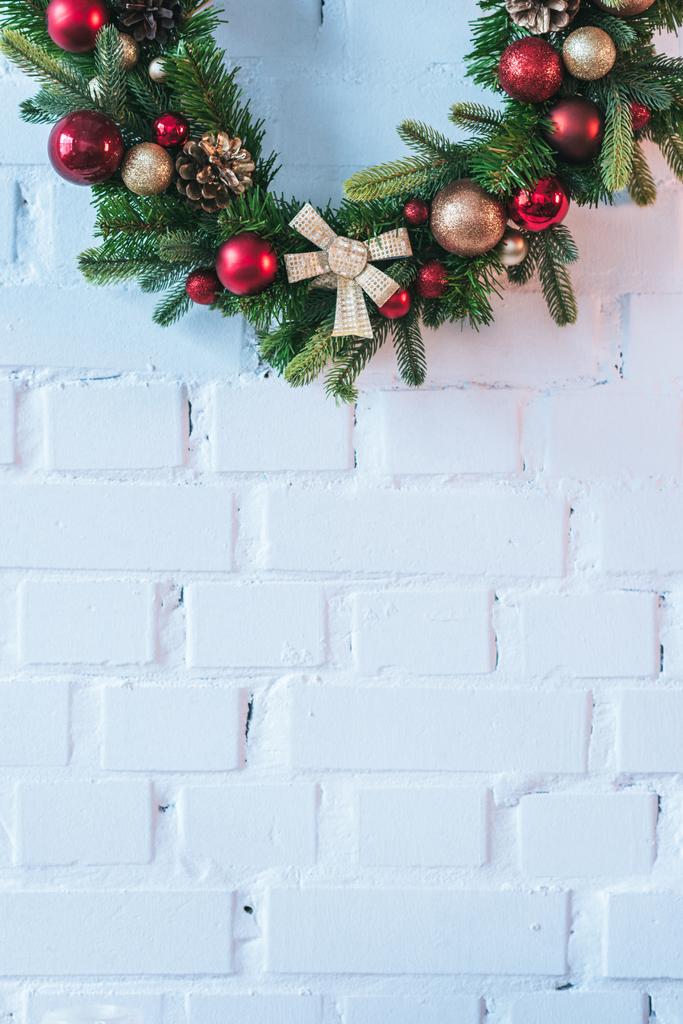 Close up van de kroon van Kerstmis op de achtergrond van witte bakstenen muur - Foto, afbeelding