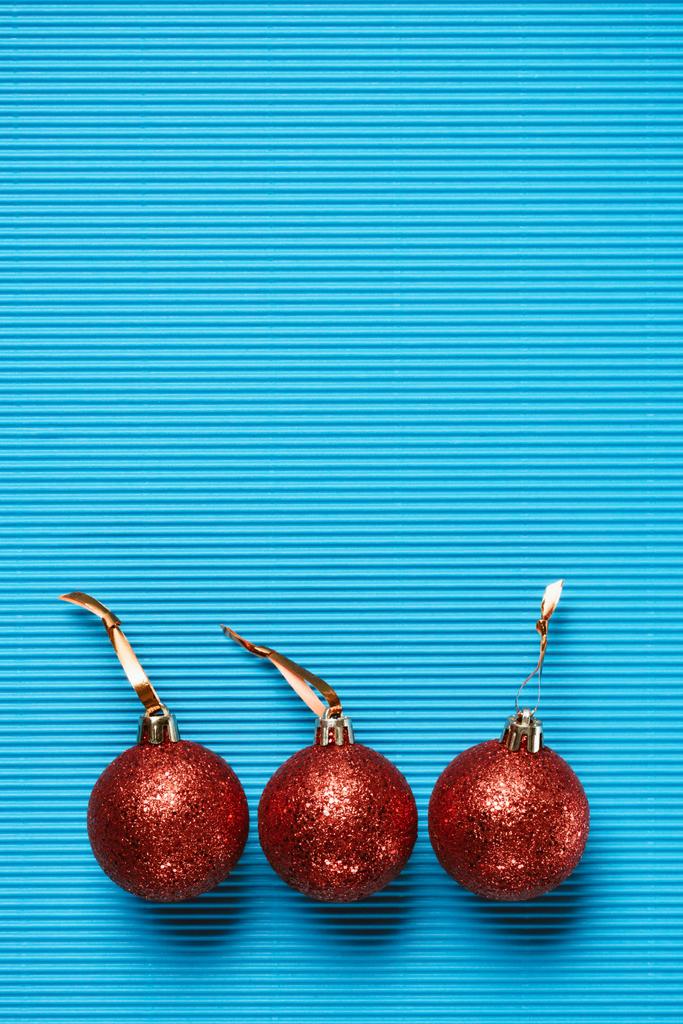 pohled shora červené lesklé dekorativní vánoční koule na modrém pozadí - Fotografie, Obrázek