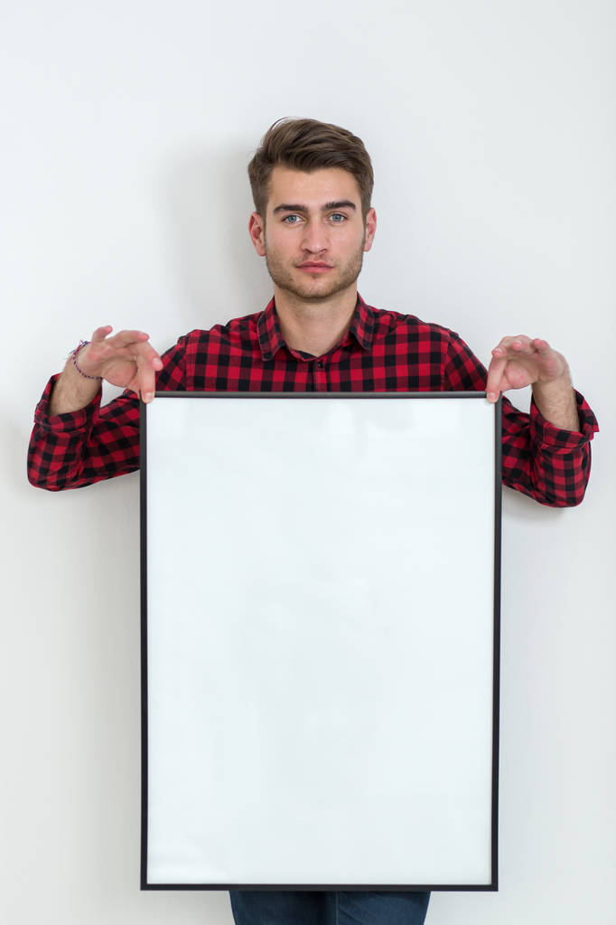Genç adam bir afiş beyaz arka plan üzerinde tutan - Fotoğraf, Görsel
