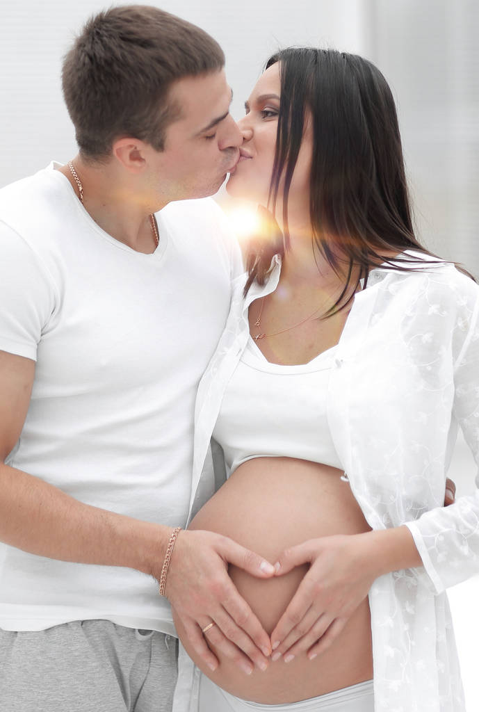 marido y mujer embarazada con las manos dobladas en forma de corazón en la barriga
 - Foto, imagen