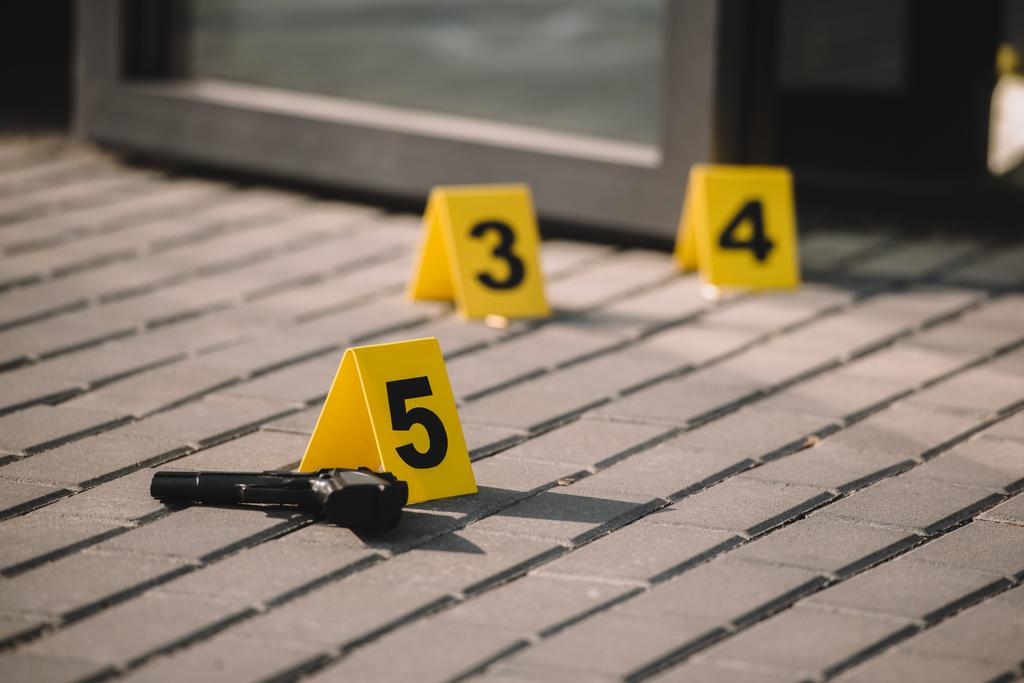 vista de cerca de la escena del crimen con arma y números
 - Foto, Imagen