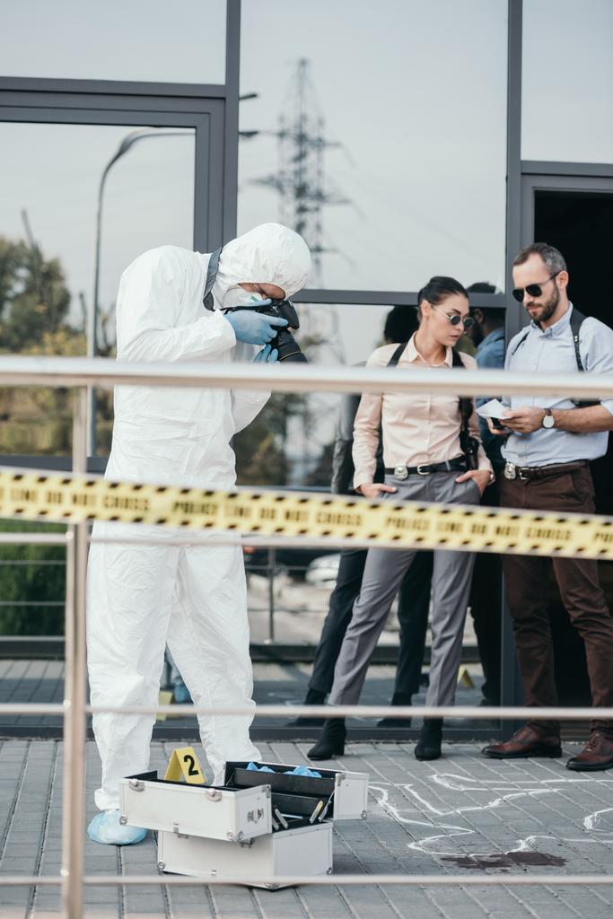 Criminologist making photo of crime scene on camera with two detectives behind him - Photo, Image