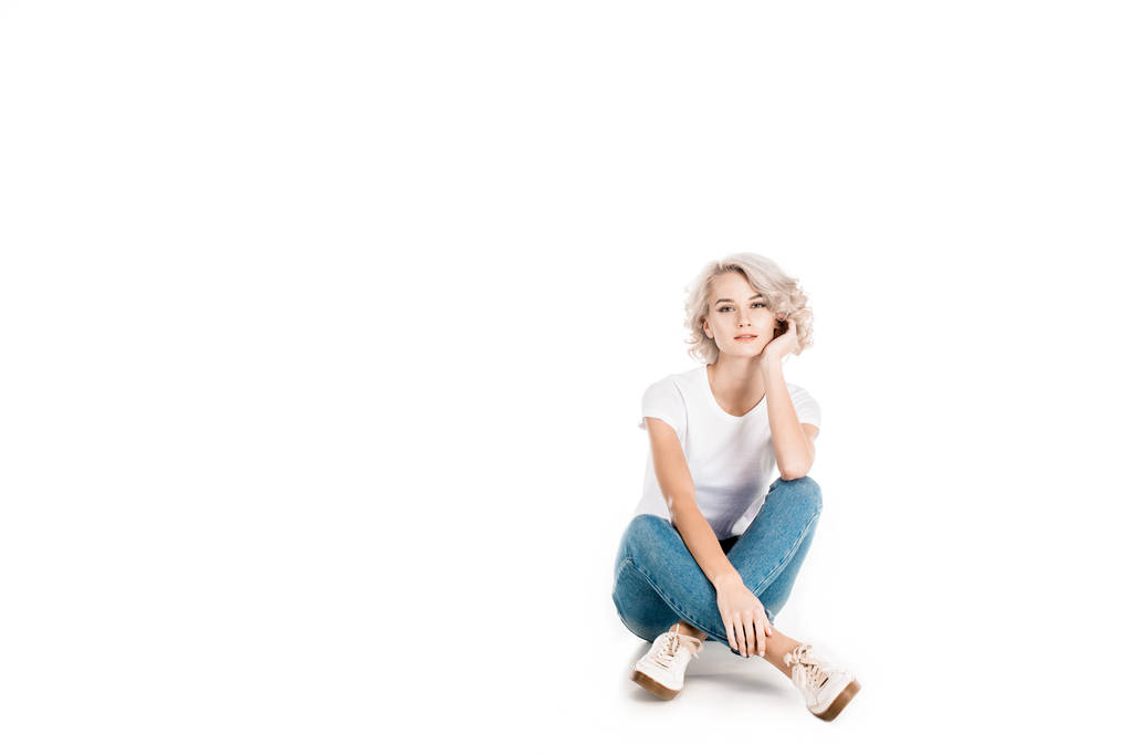 Приваблива блондинка молода доросла жінка сидить ізольовано на білому
 - Фото, зображення