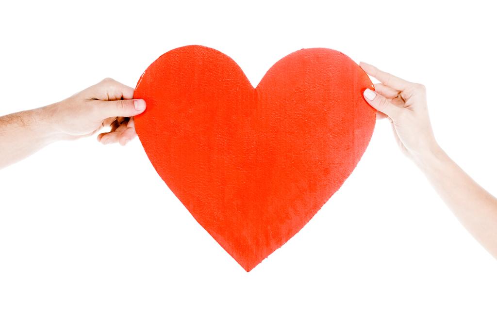 Vista parcial de pessoas segurando grande coração vermelho isolado em branco
 - Foto, Imagem