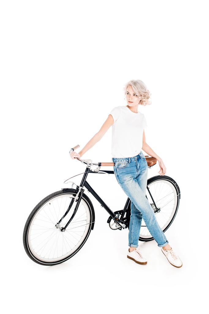 Υπέροχη ξανθιά γυναίκα που κλίνει προς το ποδήλατο που απομονώνονται σε λευκό - Φωτογραφία, εικόνα