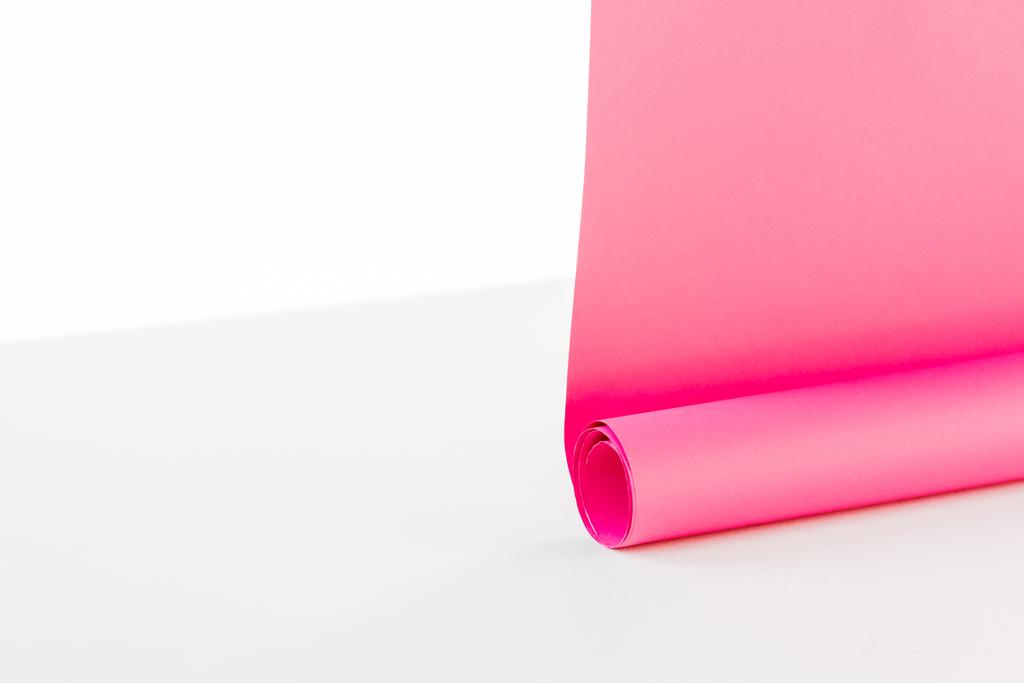 close up of bright rolled out pink paper hangings on white background - Photo, Image