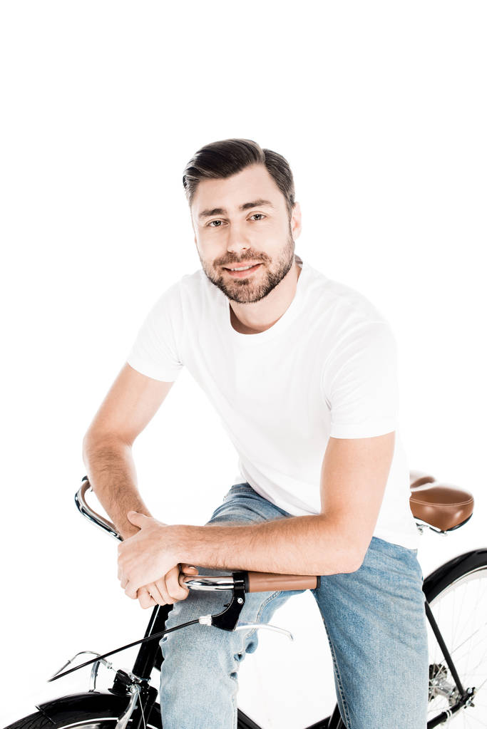Handsome smiling young adult man riding bicycle isolated on white - Photo, Image