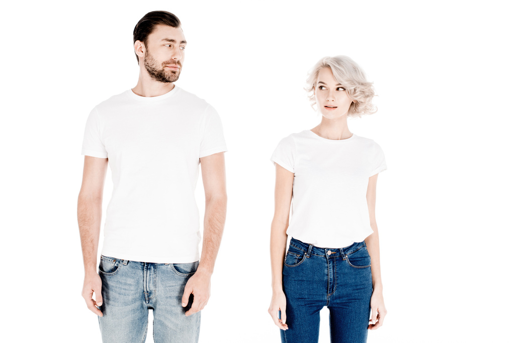 Prachtige echtpaar in witte t-shirts kijken elkaar geïsoleerd op wit - Foto, afbeelding