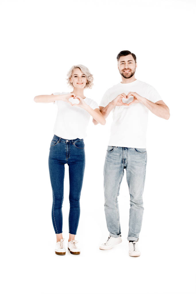 Güzel genç yetişkin çift parmak sevgiyle beyaz izole kalp şekli jest gösterilen gülümseyen - Fotoğraf, Görsel