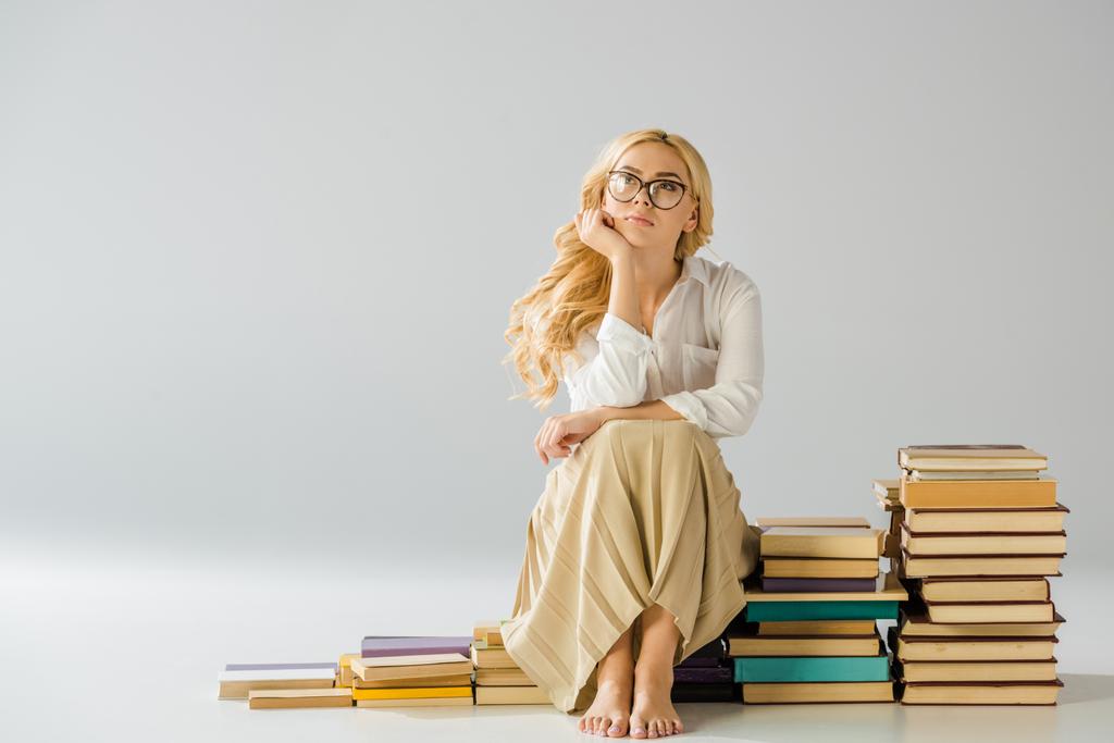 hermosa mujer descalza soñando en gafas sentadas en escalones hechos de libros
  - Foto, imagen