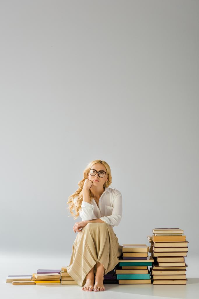 bela sonhando mulher descalça em óculos sentados em passos feitos de livros
  - Foto, Imagem