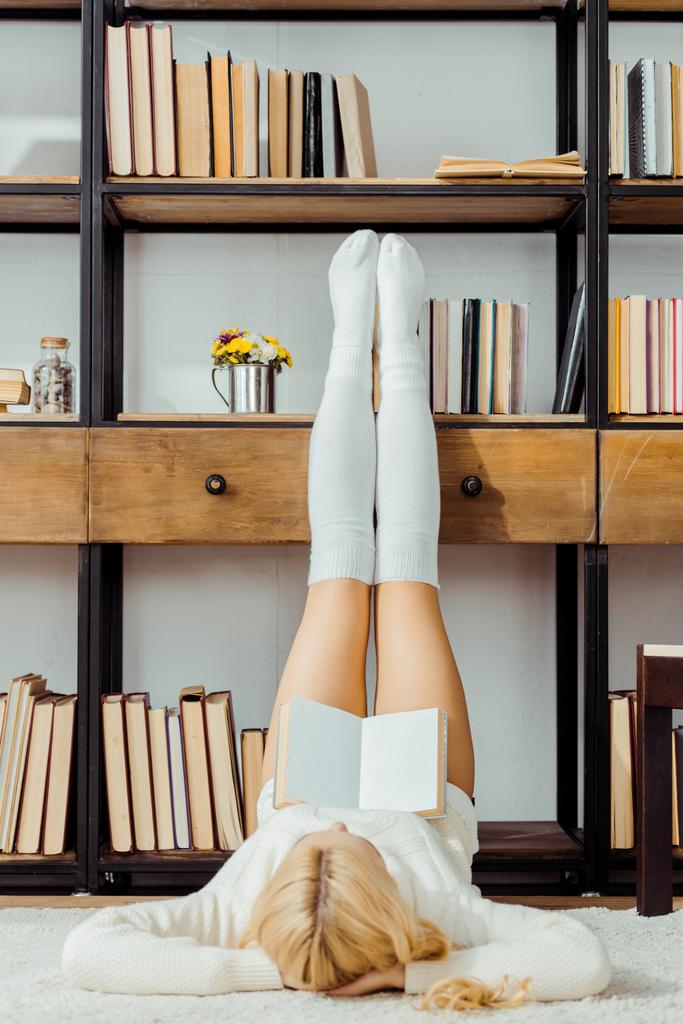 halı döşeme ve raf bacaklar ile kitap okuma kadın - Fotoğraf, Görsel