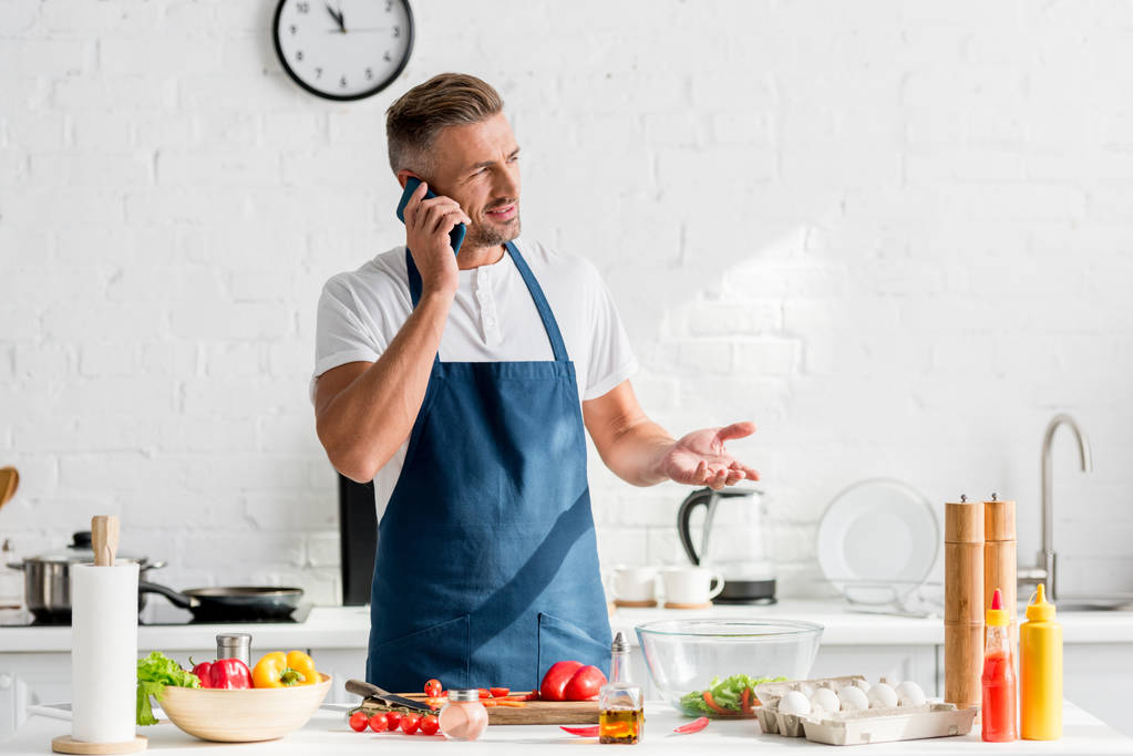  dospělý muž mluví na smartphone v kuchyni - Fotografie, Obrázek